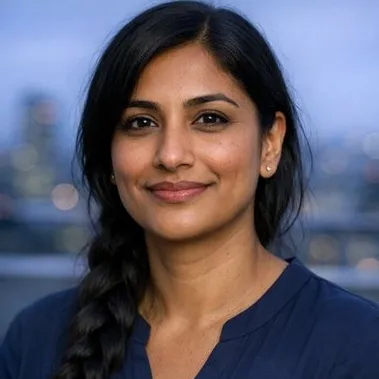 Woman in late 30s with long braided black hair, warm brown skin, calm expression
